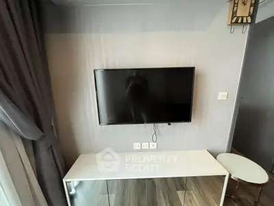 Modern living room with wall-mounted TV and sleek furniture