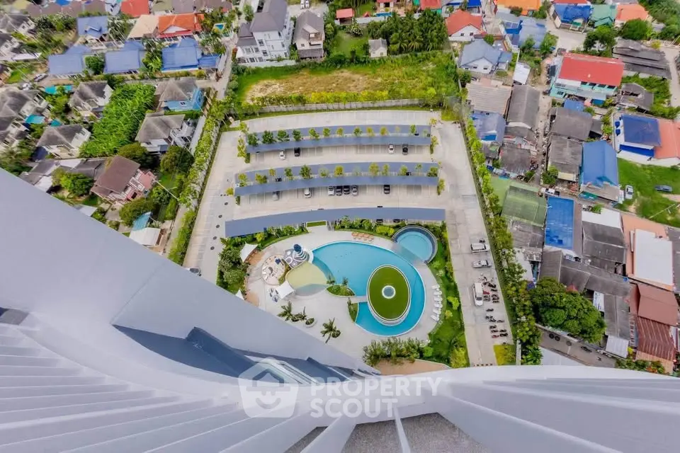 Stunning aerial view of modern building with pool and parking area in vibrant neighborhood.