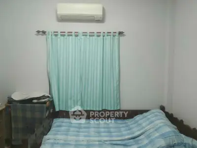 Cozy bedroom with air conditioning and striped curtains, perfect for relaxation.
