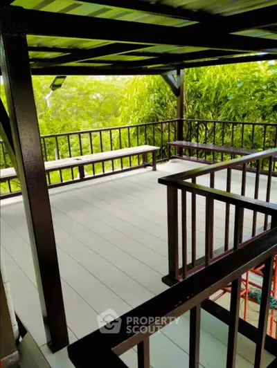 Charming outdoor balcony with lush greenery and wooden railings, perfect for relaxation and enjoying nature.