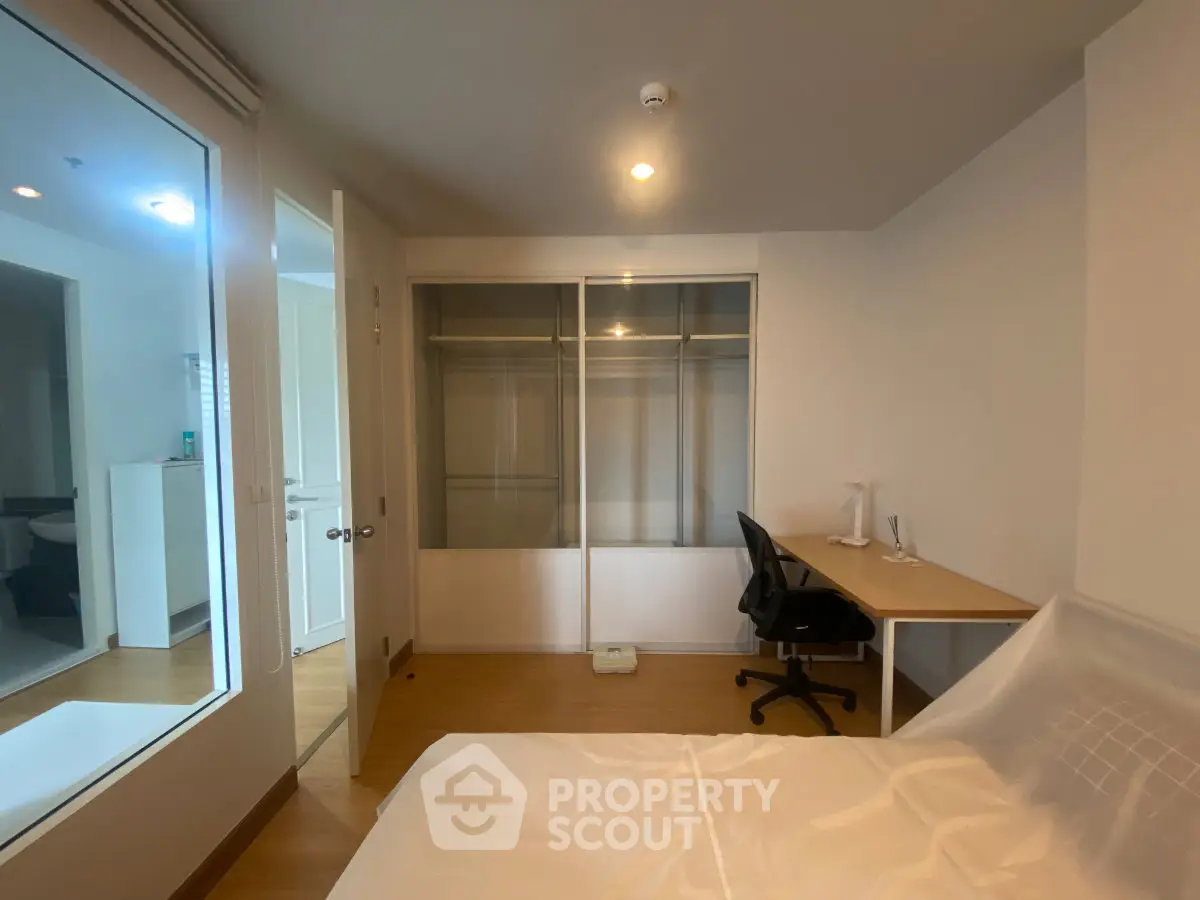 Modern bedroom with built-in closet and study desk, ideal for urban living.