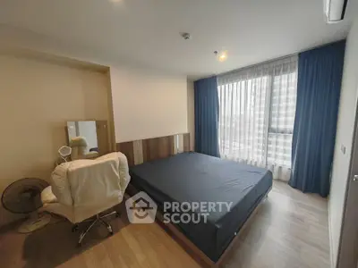 Modern bedroom with large window and stylish furnishings in urban apartment