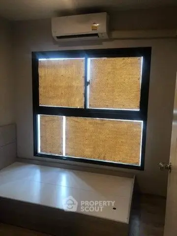 Cozy bedroom with air conditioning and large window for natural light.