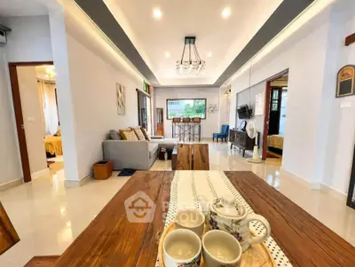 Spacious living room with modern decor and open layout, featuring a cozy seating area and elegant lighting.