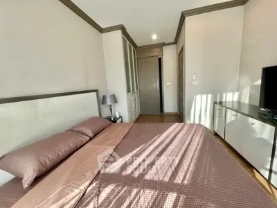 Spacious bedroom with elegant decor and ample natural light in modern apartment.