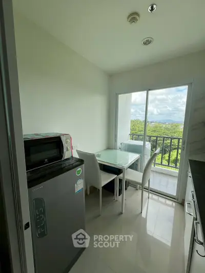 Modern kitchen with balcony view, featuring sleek appliances and dining area, perfect for urban living.