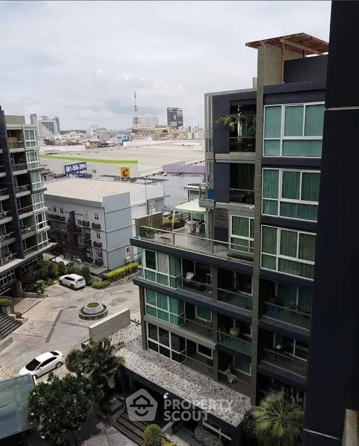Modern urban apartment building with city view and spacious balconies.