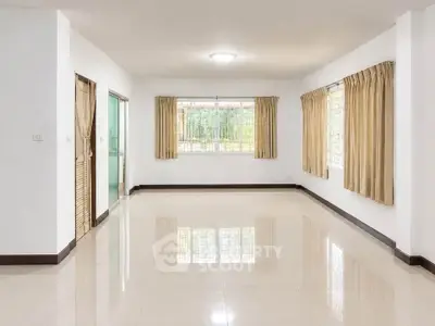 Spacious empty living room with large windows and tiled flooring
