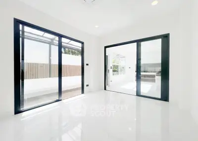 Bright modern interior with large sliding glass doors and sleek white flooring, perfect for natural light lovers.