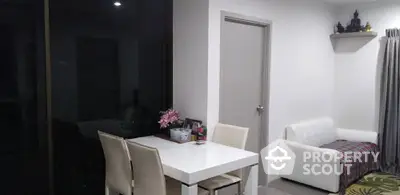 Modern dining area with white table and chairs, cozy sofa, and decorative accents.