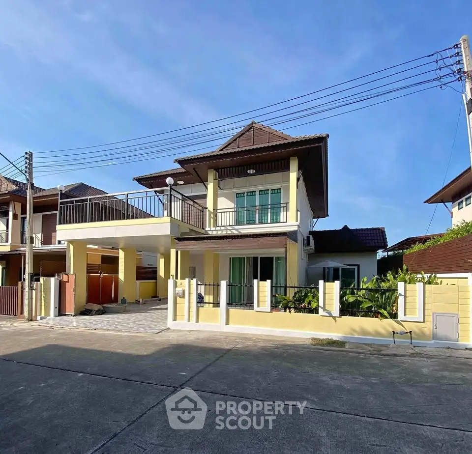 Charming two-story yellow house with spacious balcony and modern design in a serene neighborhood.