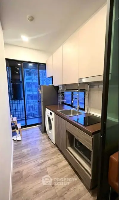 Modern kitchen with sleek appliances and open layout in urban apartment