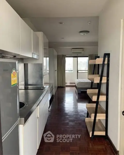 Modern studio apartment with sleek kitchen and cozy bedroom area