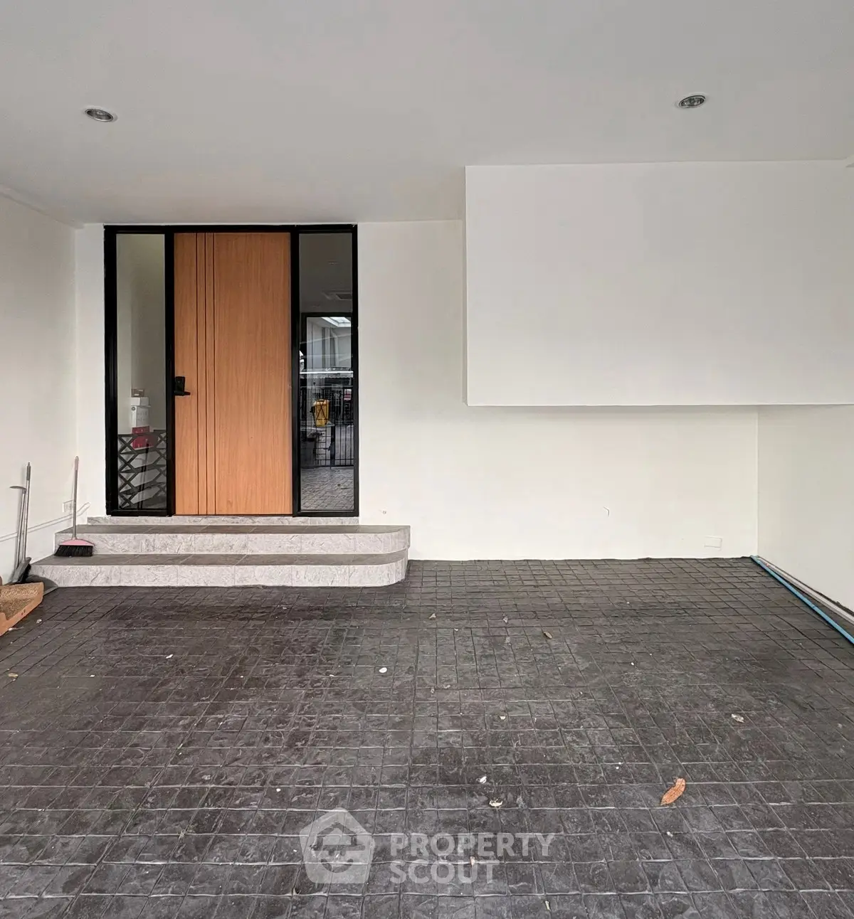 Modern minimalist entrance with sleek black-framed glass door and clean lines