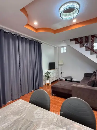 Modern living room with stylish decor and elegant lighting, featuring a cozy sectional sofa and chic curtains.