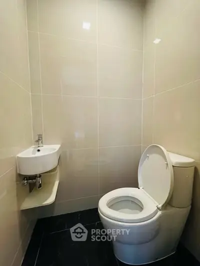 Modern minimalist bathroom with sleek fixtures and tiled walls, perfect for compact spaces.