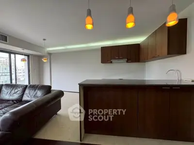 Modern open-layout living room with sleek kitchen and stylish lighting