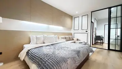 Luxurious modern bedroom with cozy bed and elegant decor, featuring a stylish sliding glass door to an adjoining room.