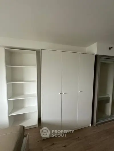 Modern bedroom with sleek white wardrobe and shelving unit