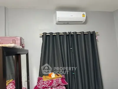 Cozy bedroom with air conditioning and stylish curtains, perfect for comfortable living.