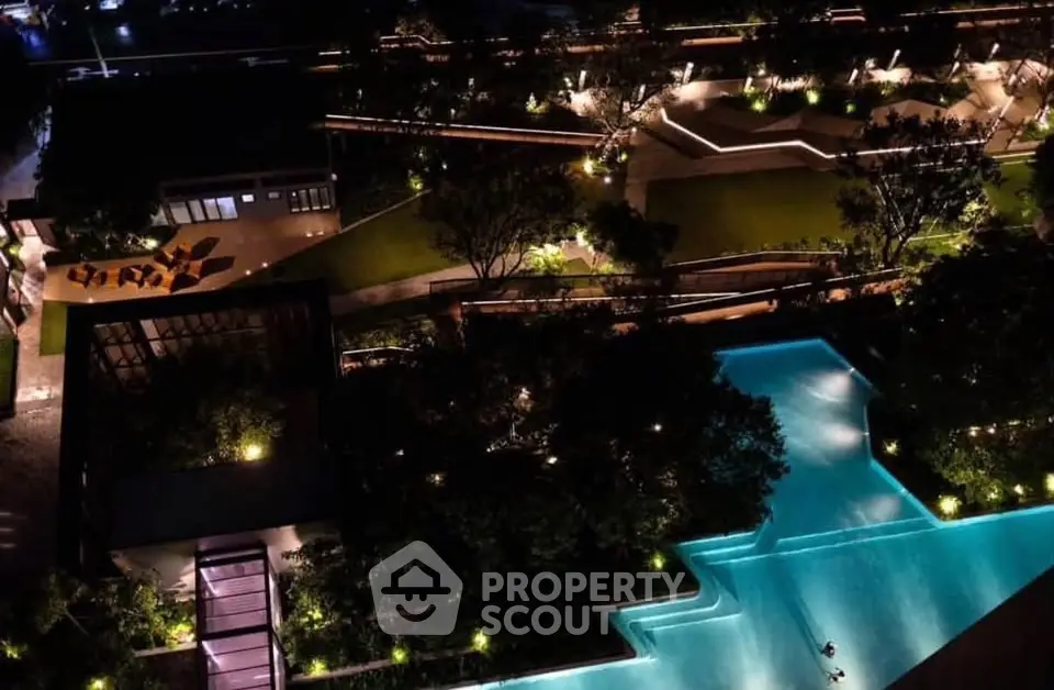 Luxurious night view of illuminated pool and landscaped garden in upscale residential complex.