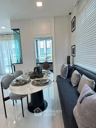 Modern dining area with elegant table setting and cozy seating in a stylish apartment.