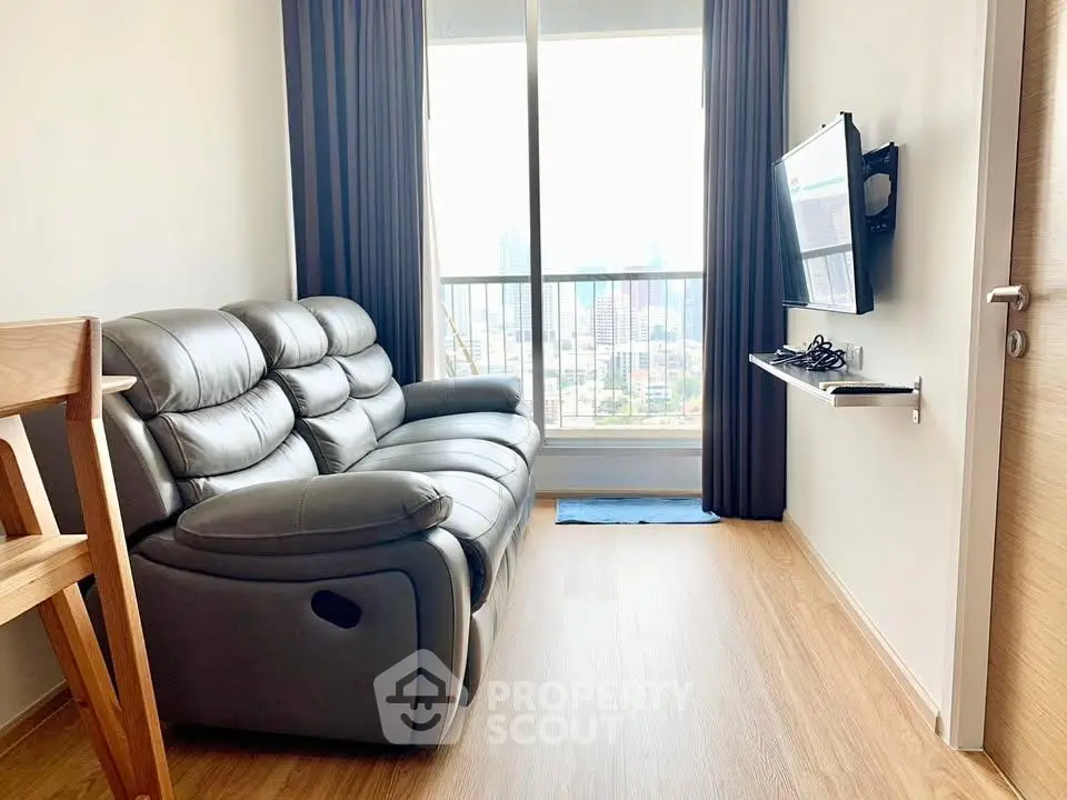 Modern living room with sleek leather sofa and wall-mounted TV, featuring a stunning city view.