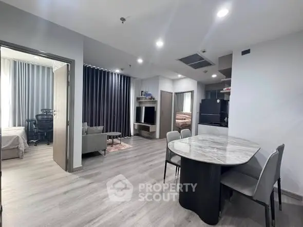 Modern open-plan living room with dining area and kitchen in a stylish apartment.