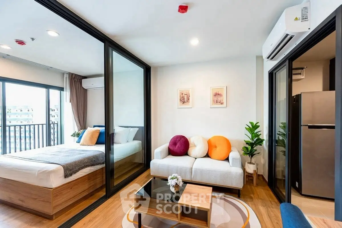 Modern studio apartment with open layout, featuring a cozy living area and bedroom with balcony view.