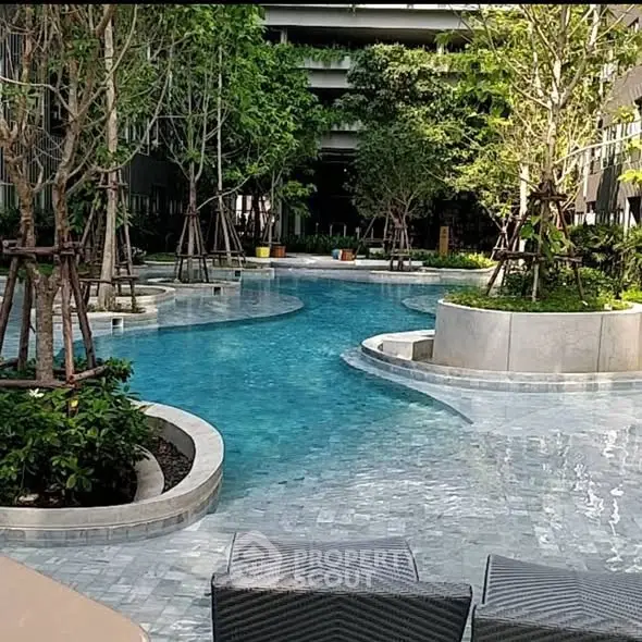 Luxurious residential pool area with lush greenery and modern design.