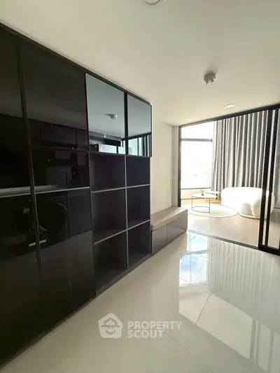 Modern apartment interior with sleek black cabinetry and bright living area.