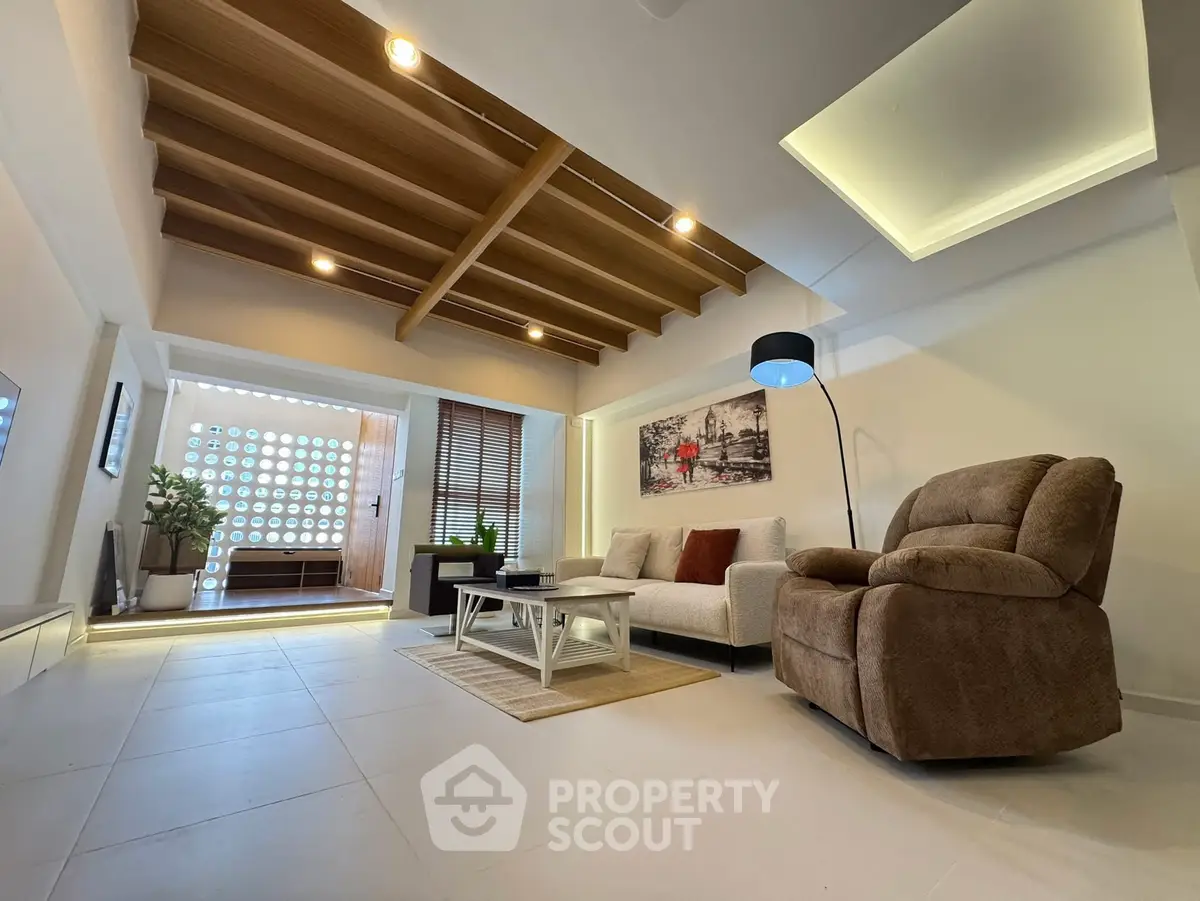Stylish modern living room with cozy seating and unique ceiling design.