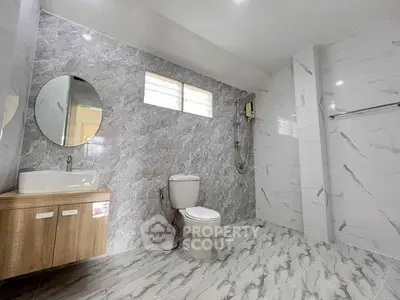 Spacious modern bathroom with elegant marble tiles and sleek fixtures.