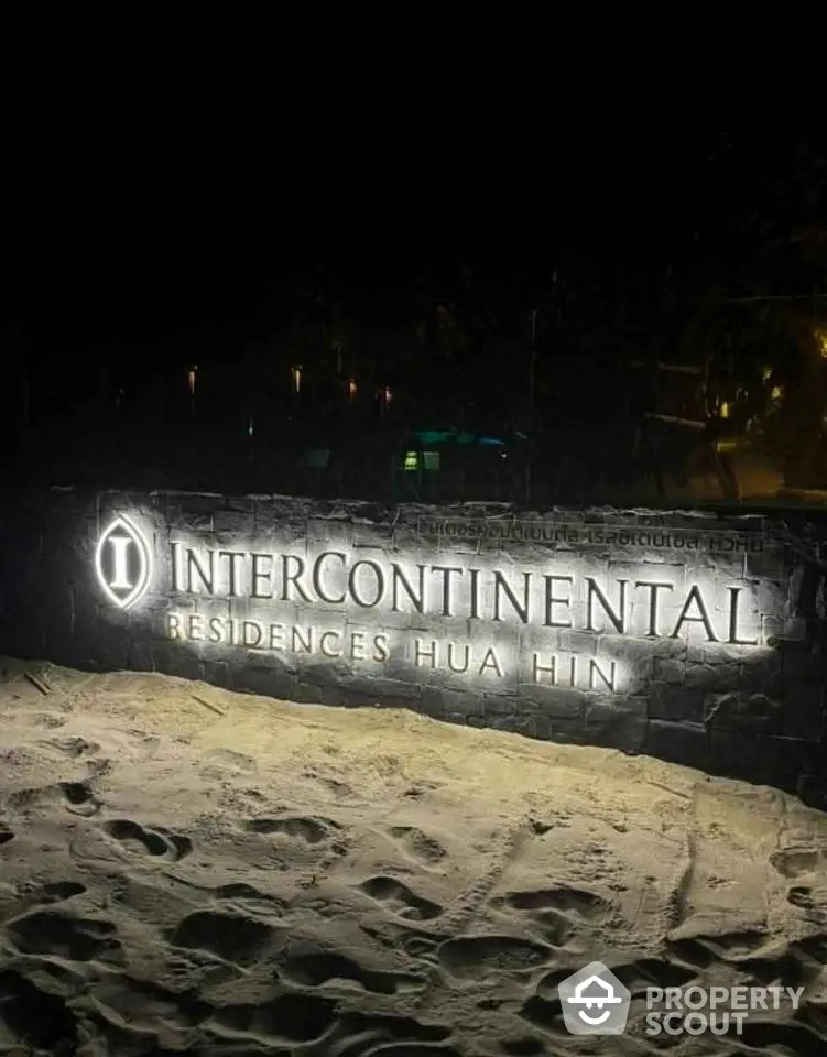 InterContinental Residences Hua Hin illuminated sign on sandy beach at night