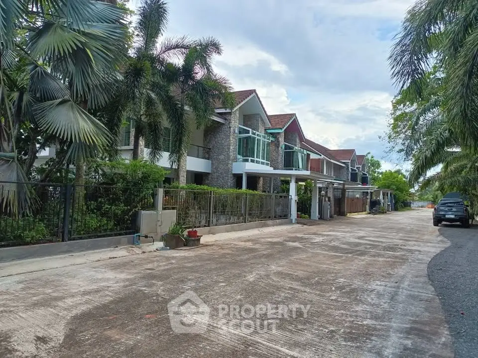 Charming suburban row houses with lush greenery and spacious driveways.