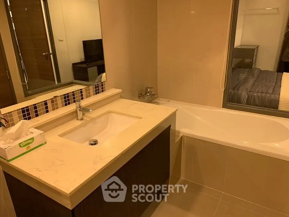 Modern bathroom with sleek vanity and bathtub in a stylish apartment.