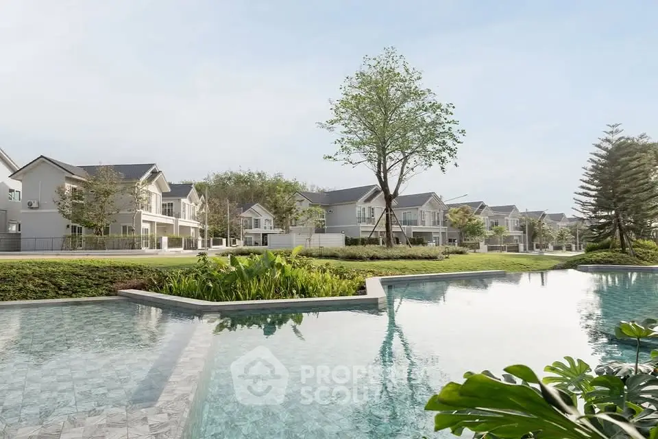 Luxurious residential community with modern homes and serene pool view.