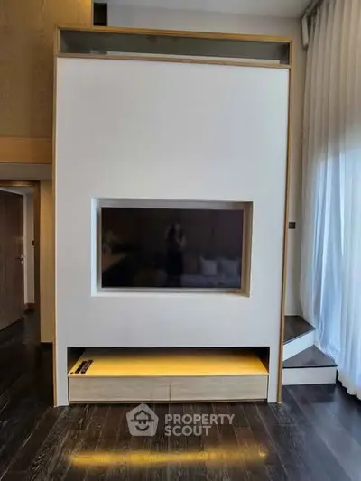 Modern living room with sleek built-in TV unit and elegant curtains