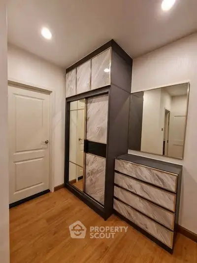Modern bedroom with stylish wardrobe and dresser, featuring sleek design and ample storage space.
