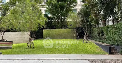 Lush green garden with manicured lawn and trees in a serene residential setting.