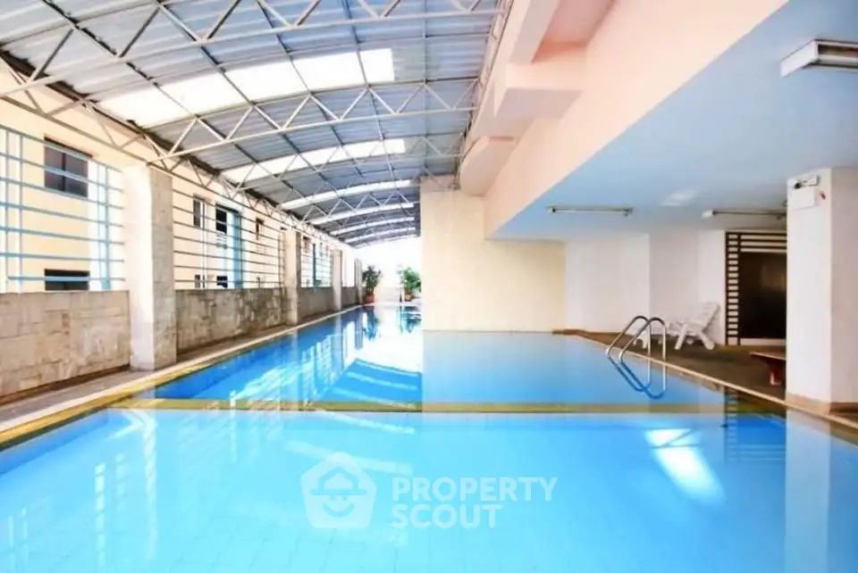 Luxurious indoor swimming pool with modern design and ample natural light in a premium real estate property.