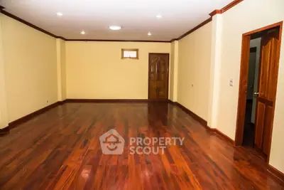 Spacious empty room with polished wooden floors and elegant door