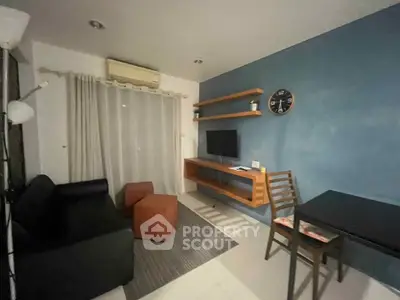 Modern living room with sleek furniture and wall-mounted TV in a cozy apartment.
