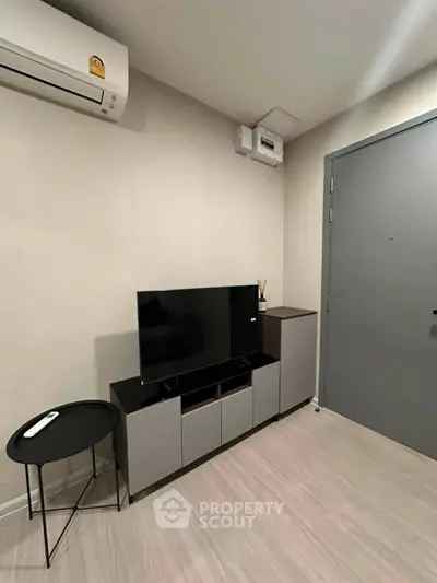 Modern living room with sleek TV stand and air conditioning unit, perfect for cozy entertainment.