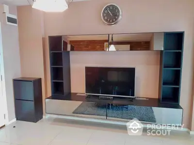 Modern living room with sleek entertainment center and wall-mounted clock.