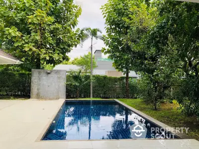 Luxurious private pool surrounded by lush greenery in serene backyard setting