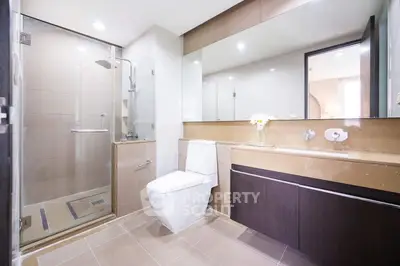 Modern bathroom with glass shower and elegant vanity in a stylish home.