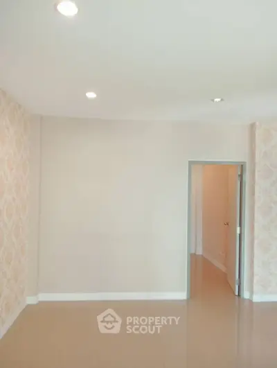 Spacious empty room with elegant wallpaper and recessed lighting