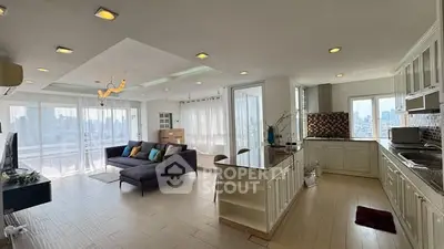 Spacious open-plan living room and kitchen with modern design and city view.