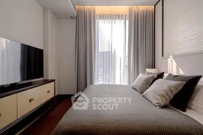 Modern bedroom with elegant decor and natural light through large window.